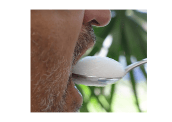 A very close up shot of a man eating his food off a spoon.